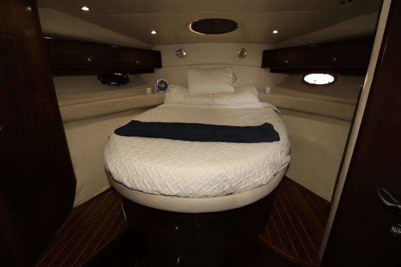 Long Overdue Yacht Photos Pics Luxurious cabin interior of 2002 Regal Commodore 4260 yacht with cozy bed and ambient lighting.