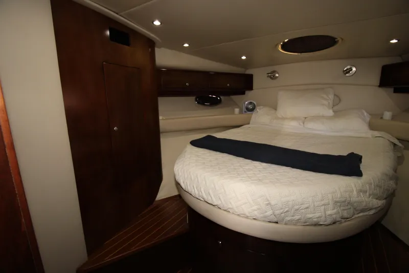 Long Overdue Yacht Photos Pics Luxurious cabin interior of 2002 Regal Commodore 4260 yacht with cozy bed and elegant wood finish.