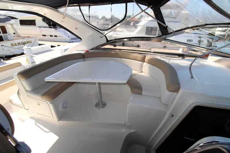 Long Overdue Yacht Photos Pics 2002 Regal Commodore 4260 yacht interior with curved seating and table.