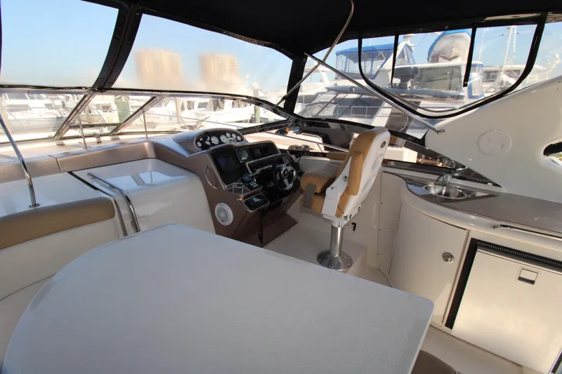 Long Overdue Yacht Photos Pics 2002 Regal Commodore 4260 yacht cockpit with helm, seating, and panoramic windows.