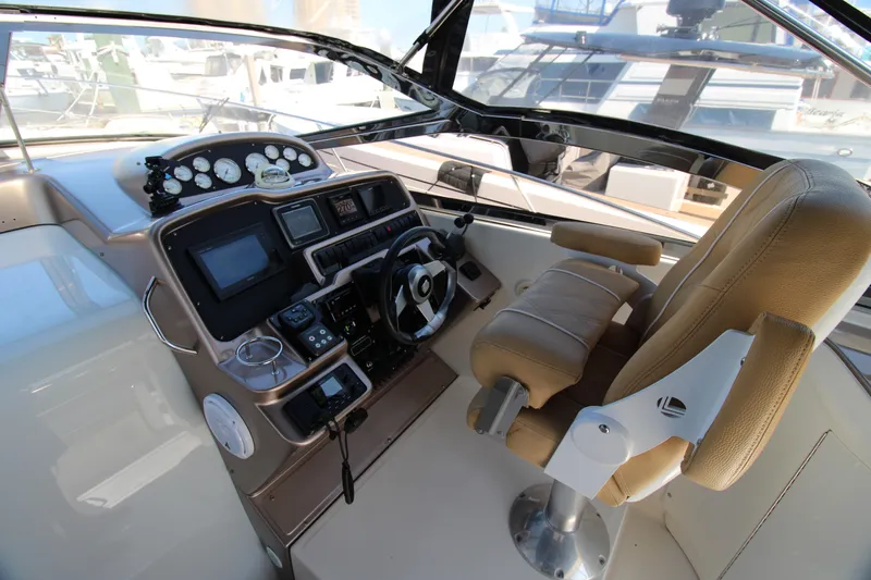 Long Overdue Yacht Photos Pics Helm of 2002 Regal Commodore 4260 yacht with steering wheel and navigation controls.