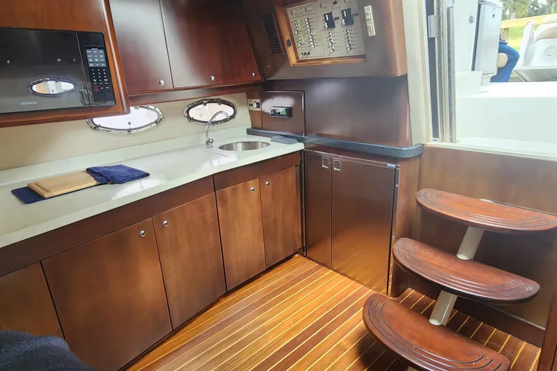 Long Overdue Yacht Photos Pics Luxurious 2002 Regal Commodore 4260 yacht interior with wooden cabinetry and modern kitchen amenities.