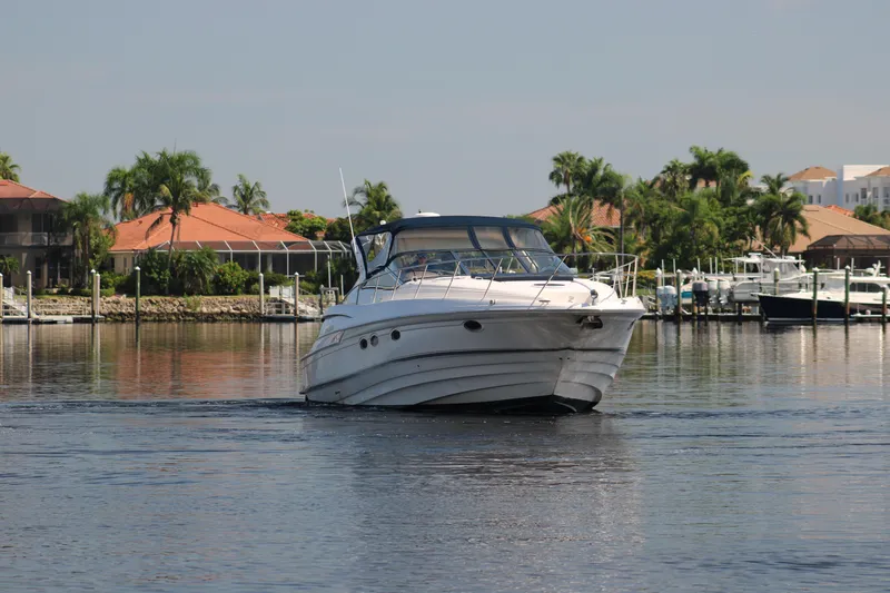 Long Overdue Yacht Photos Pics 2002 Regal Commodore 4260 yacht cruising near waterfront homes with palm trees.