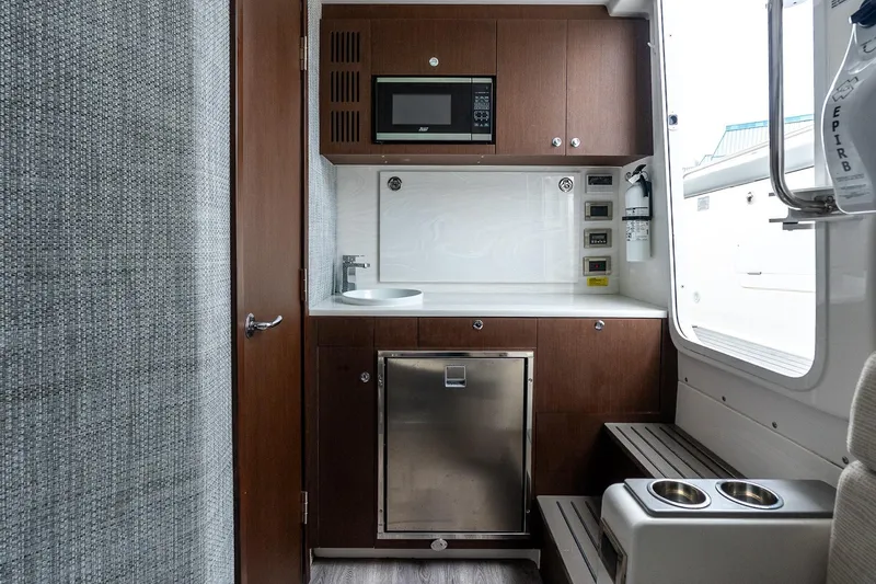 Montrachet Yacht Photos Pics 2023 Everglades 455 Center Console interior with kitchenette, microwave, and storage.