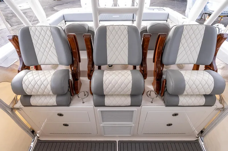 Montrachet Yacht Photos Pics Luxurious seating on 2023 Everglades 455 Center Console boat, featuring quilted upholstery and wooden accents.