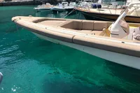 1996 Maxi Custom Tender boat docked in clear turquoise water, surrounded by other vessels.