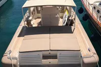 1996 Maxi Custom Tender boat docked in clear blue water, featuring spacious deck and seating.