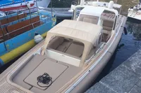 1996 Maxi Custom Tender boat docked at marina, featuring beige canopy and seating.
