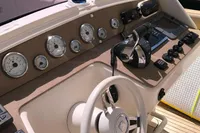 Control panel of a 1996 Maxi Custom Tender boat with gauges and steering wheel.