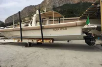 1996 Maxi Custom Tender boat on trailer, set against rocky landscape.