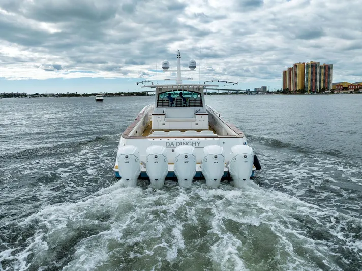 Da Dinghy Yacht Photos Pics 2021 HCB Estrella boat cruising on water with five engines, cityscape in background.