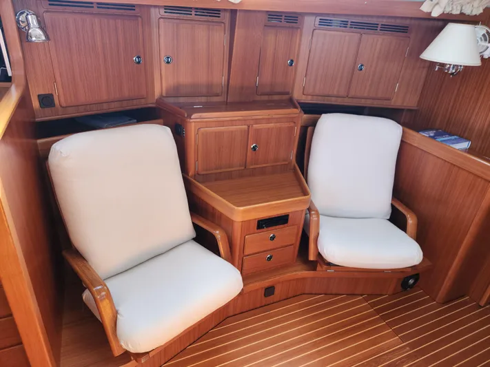 Just Do It Yacht Photos Pics Interior of 2006 Hallberg-Rassy 53 yacht with wooden cabinetry and cushioned seating.