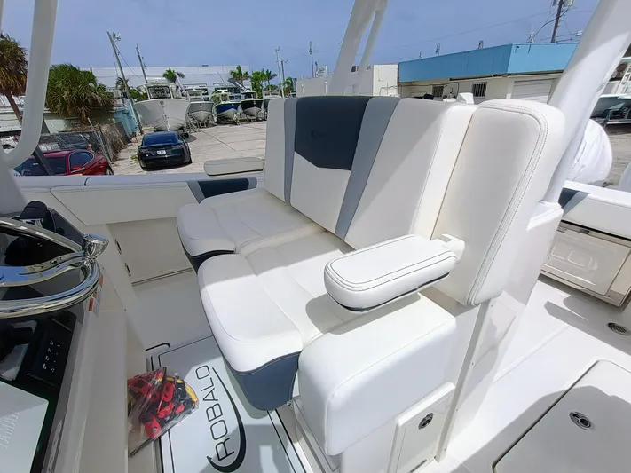 270-152 Yacht Photos Pics 2025 Robalo R270 Center Console boat with white and gray seating, docked outdoors.