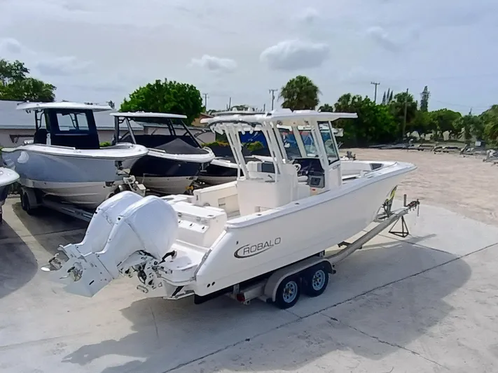 270-152 Yacht Photos Pics 2025 Robalo R270 Center Console boat on trailer, parked outdoors.