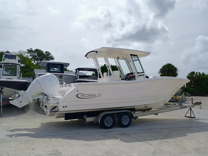 270-152 Yacht Photos Pics 2025 Robalo R270 Center Console boat on trailer, parked outdoors.