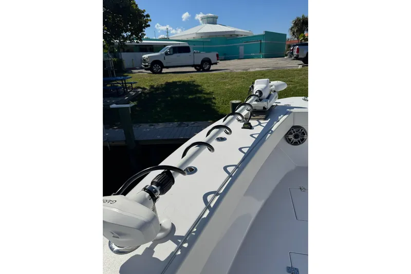  Yacht Photos Pics 2007 Conch 27 boat with trolling motor, docked near a parking area.