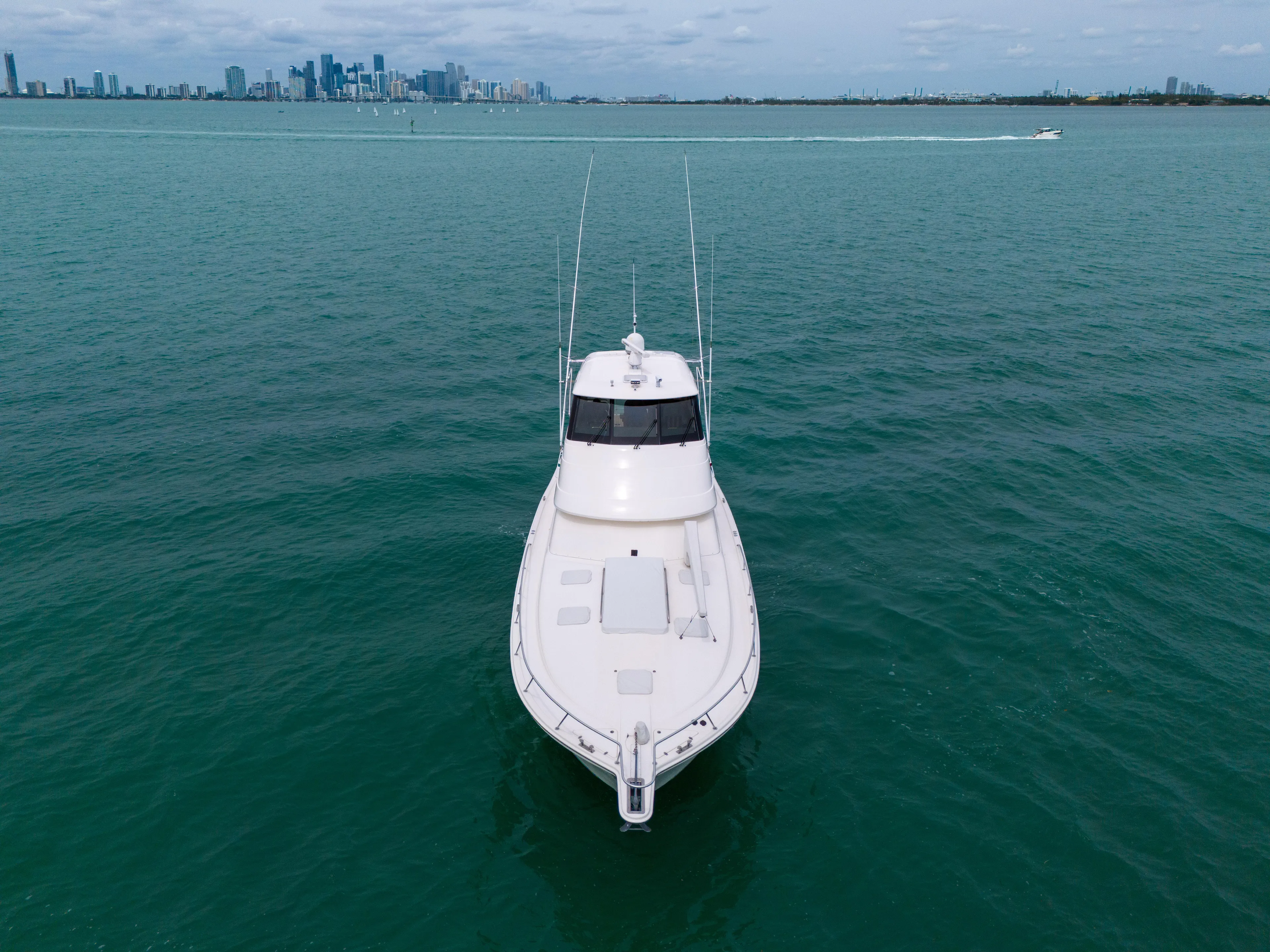  Yacht Photos Pics 2008 Riviera 51 Enclosed Bridge yacht cruising on open water with city skyline in background.