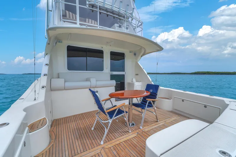  Yacht Photos Pics 2008 Riviera 51 Enclosed Bridge yacht with deck chairs and table on open sea.