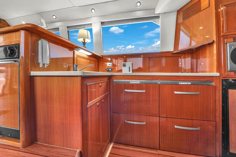  Yacht Photos Pics Luxurious 2008 Riviera 51 Enclosed Bridge yacht interior with polished wood cabinetry and modern amenities.