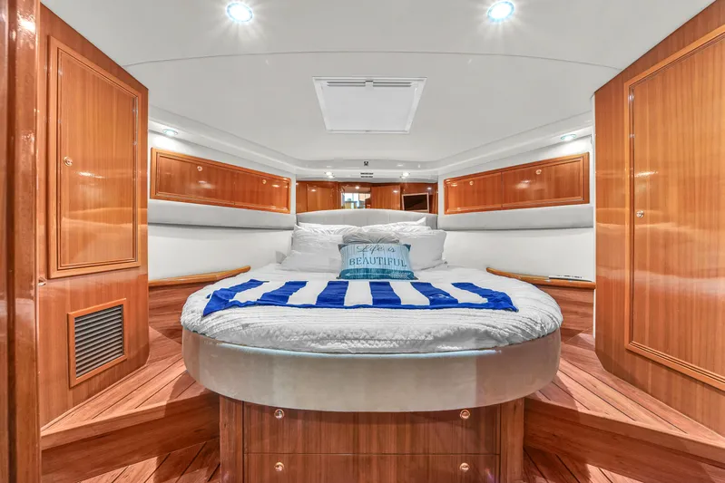  Yacht Photos Pics Luxurious bedroom interior of 2008 Riviera 51 Enclosed Bridge yacht with wood paneling.