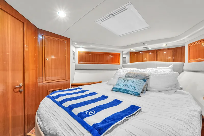  Yacht Photos Pics Luxurious bedroom interior of 2008 Riviera 51 Enclosed Bridge yacht with elegant wood finishes.