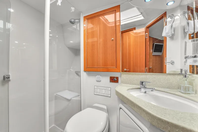  Yacht Photos Pics Luxurious bathroom in 2008 Riviera 51 Enclosed Bridge yacht with modern fixtures and wooden cabinetry.