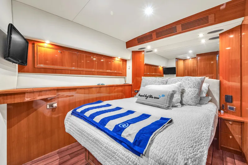  Yacht Photos Pics Luxurious bedroom interior of 2008 Riviera 51 Enclosed Bridge yacht with wood paneling and cozy bedding.