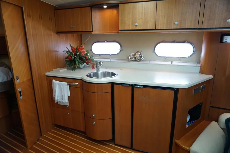 The Pearl Yacht Photos Pics 2007 Tiara Yachts 3900 Sovran interior with wooden cabinetry and compact kitchen area.