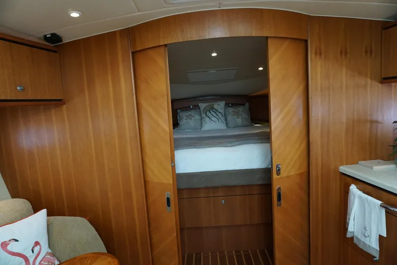 The Pearl Yacht Photos Pics Luxurious 2007 Tiara Yachts 3900 Sovran cabin interior with wood paneling and cozy bedding.