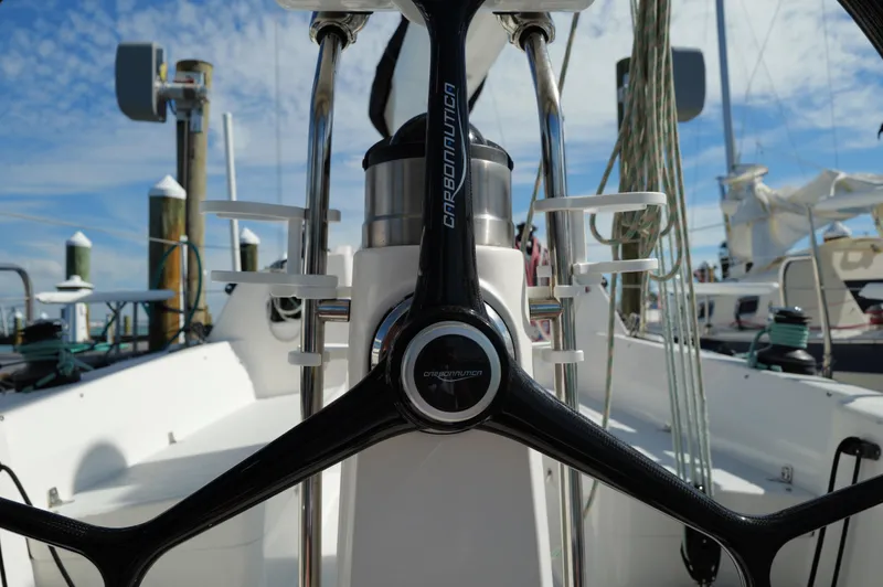 Encore Yacht Photos Pics Steering wheel of 2011 J Boats J/95 sailboat, docked with clear sky background.