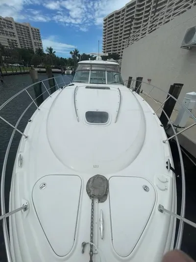 Lucky Duck Yacht Photos Pics 2005 Sea Ray 420 Sundancer yacht docked near waterfront buildings.