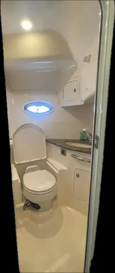 Lucky Duck Yacht Photos Pics 2005 Sea Ray 420 Sundancer bathroom with toilet, sink, and porthole window.