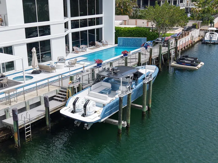 Chin Don Yacht Photos Pics 2023 Limitless Seas 45 XLV yacht docked by a luxurious waterfront property.