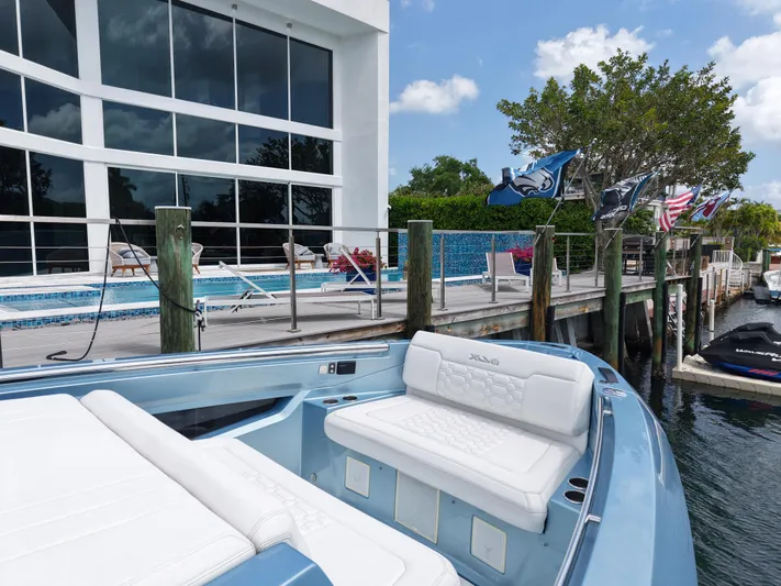 Chin Don Yacht Photos Pics Luxurious Limitless Seas 45 XLV yacht docked by a modern waterfront property, 2023 model.