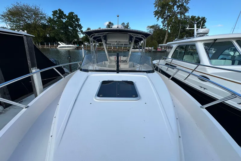  Yacht Photos Pics 1999 Intrepid 339 boat docked between other vessels on a calm waterway.