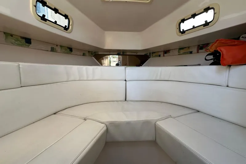  Yacht Photos Pics Interior of a 1999 Intrepid 339 boat with white cushioned seating.