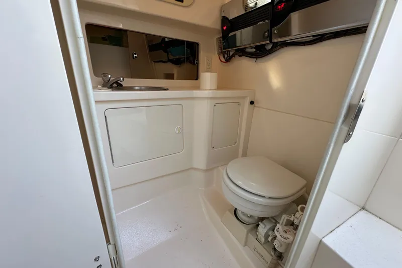  Yacht Photos Pics 1999 Intrepid 339 boat bathroom with sink, toilet, and storage cabinets.