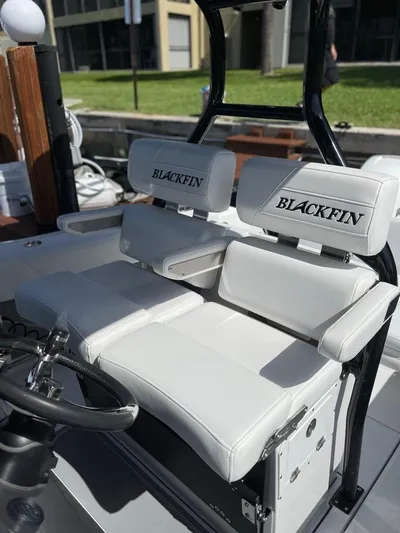  Yacht Photos Pics 2019 Blackfin 272 CC boat with white cushioned seating and steering wheel.