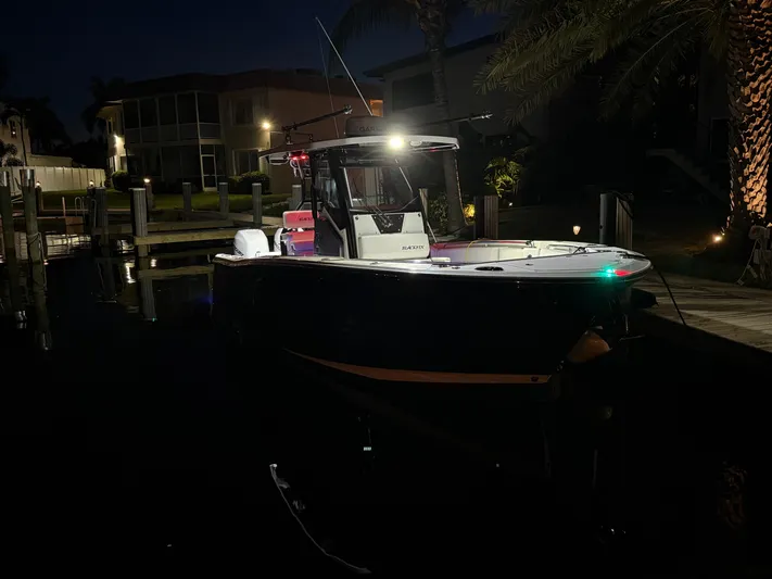  Yacht Photos Pics 2019 Blackfin 272 CC boat docked at night, illuminated by lights.