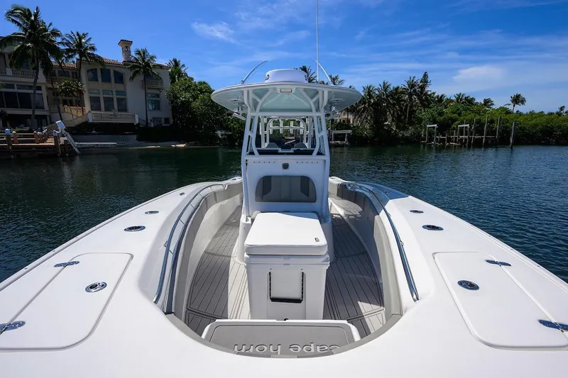  Yacht Photos Pics 2024 Cape Horn 31 T boat on calm water, surrounded by lush greenery.