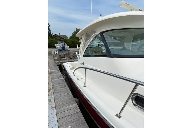 Jambo Yacht Photos Pics 2011 Pursuit OS 345 Offshore boat docked at a marina, side view.