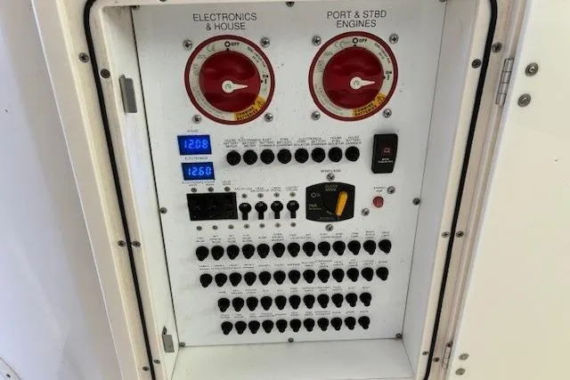 Jambo Yacht Photos Pics Control panel of a 2011 Pursuit OS 345 Offshore boat, featuring switches and gauges.