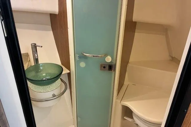 Jambo Yacht Photos Pics 2011 Pursuit OS 345 Offshore boat bathroom with glass sink and compact toilet.