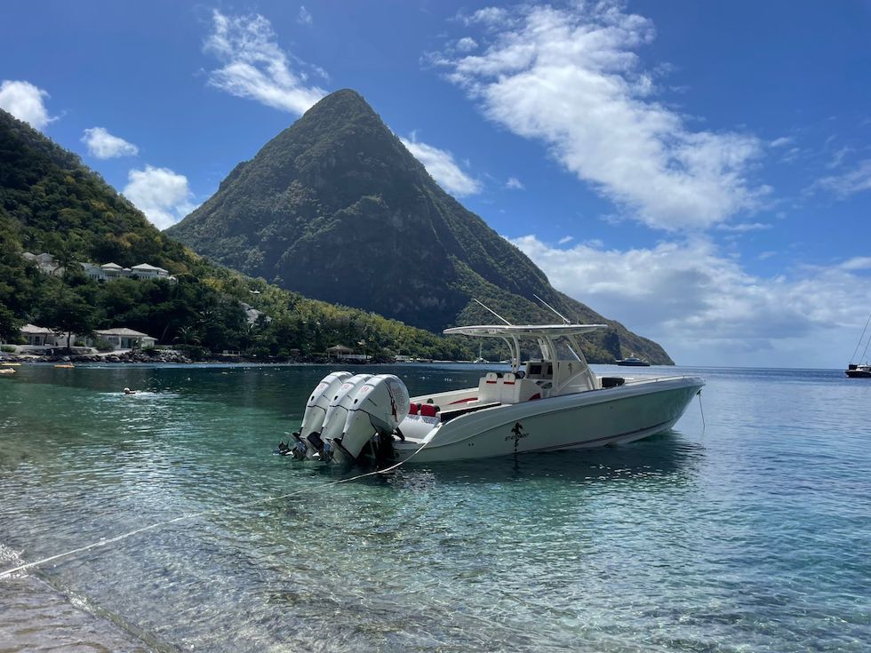 2017 Statement 380 SUV Cuddy boat anchored near a scenic mountain backdrop.