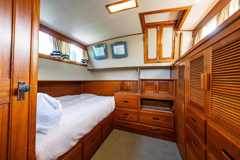Sojourn Yacht Photos Pics Cozy cabin interior of 1990 Grand Banks 36 Classic with wooden furnishings and bed.