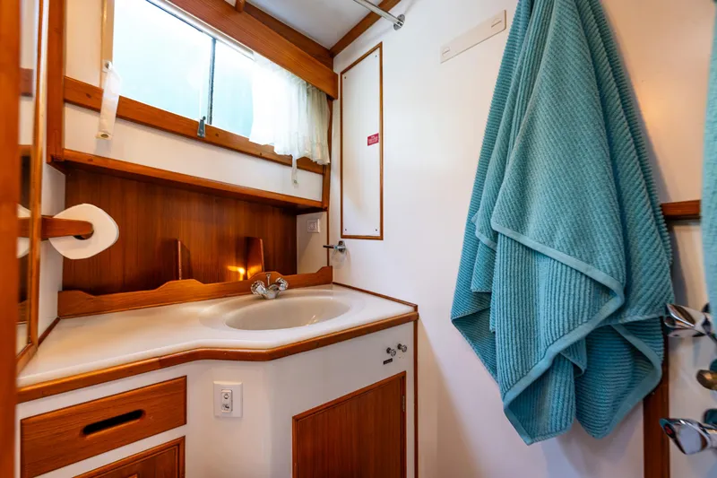 Sojourn Yacht Photos Pics Bathroom interior of 1990 Grand Banks 36 Classic yacht with wooden accents and teal towel.