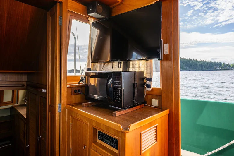 Sojourn Yacht Photos Pics Interior of 1990 Grand Banks 36 Classic yacht with TV and microwave, overlooking water.
