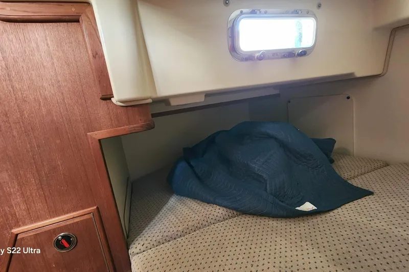 Ramble On Yacht Photos Pics Cozy cabin interior of 2000 Island Packet 380 sailboat with bedding and porthole.