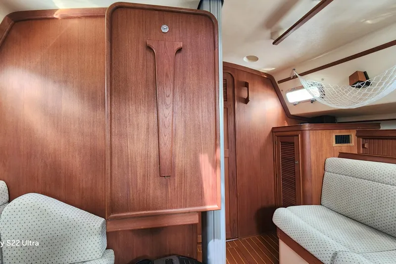 Ramble On Yacht Photos Pics Interior of 2000 Island Packet 380 sailboat with wood paneling and cushioned seating.