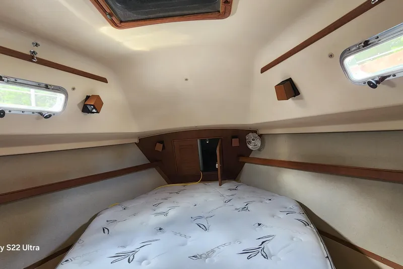 Ramble On Yacht Photos Pics Cozy cabin interior of 2000 Island Packet 380 sailboat with mattress and portholes.
